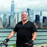 Dennis Gibbons with a bike in front of a city