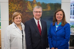 Three professionals smile together