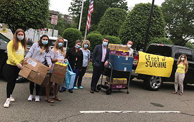 Volunteers from Six Feet of Sunshine dropping off boxes for adult and pediatric patients filled with snacks, stickers, pencils, chapstick, games and more.